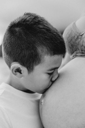 Black and white photo series showing tender moments between child and parent on a beach.