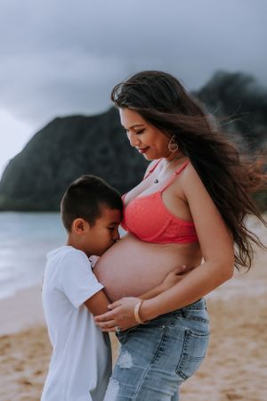 Emotional maternity beach photos showing children connecting with their expectant mother.