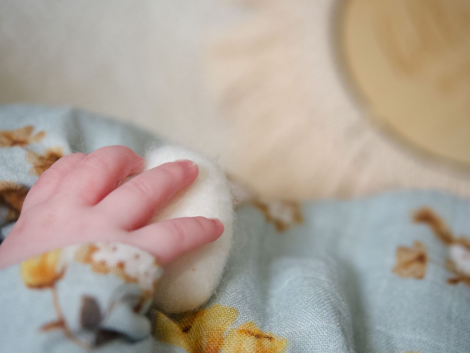 Lifestyle newborn session of newborn baby hand holding a white heart