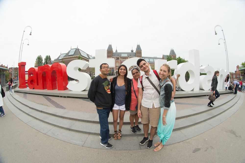 Tourists posing with the iconic I Amsterdam sign in the Netherlands.