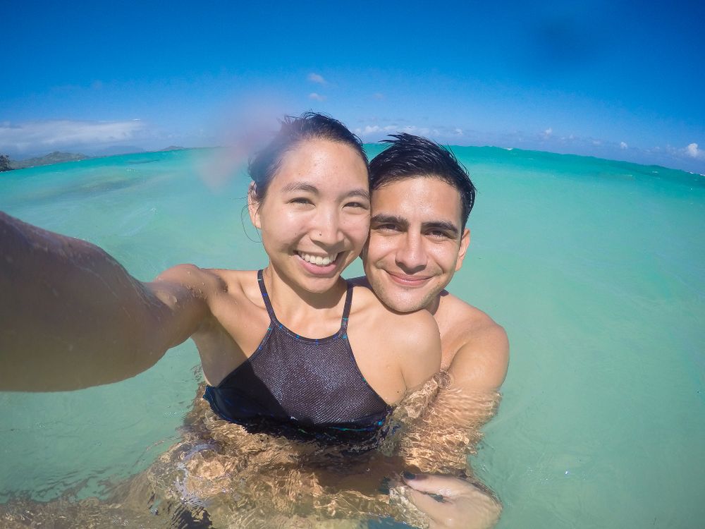 Tropical beach scene with crystal clear turquoise waters and sunny blue sky.