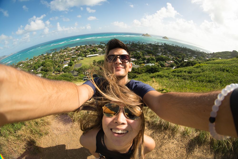 Tropical island panorama with turquoise waters and lush green hills under blue skies.