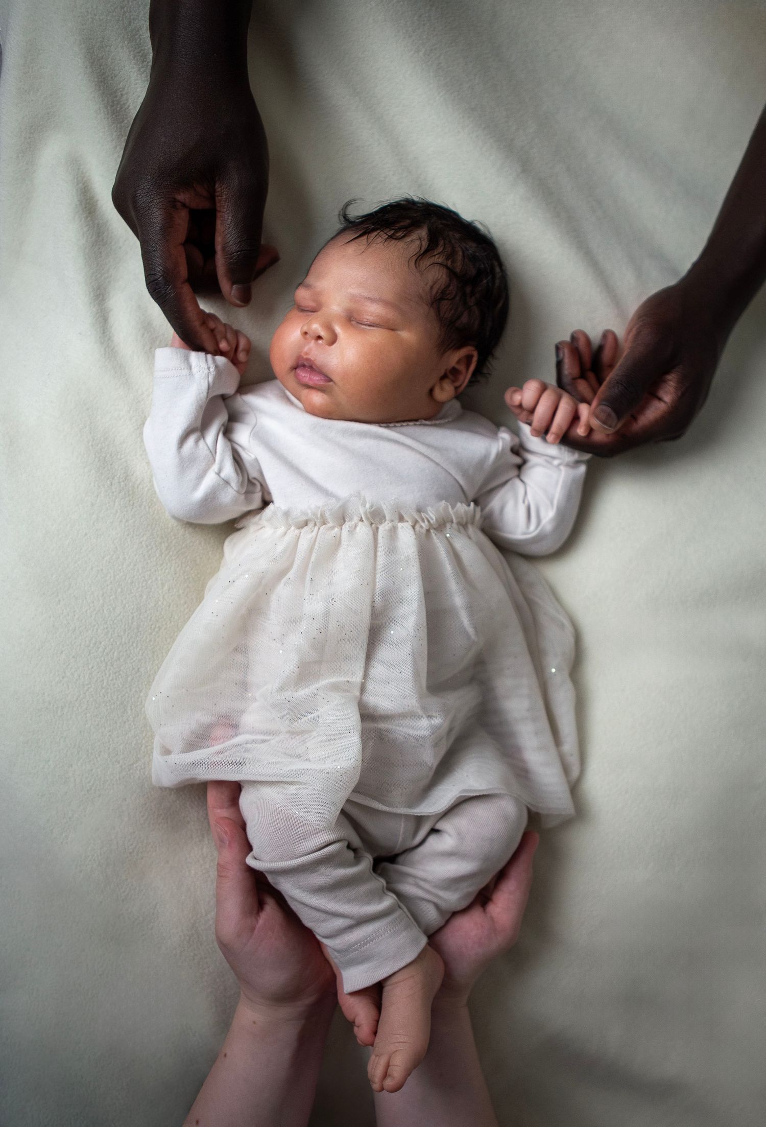 newborn baby with parents' hands