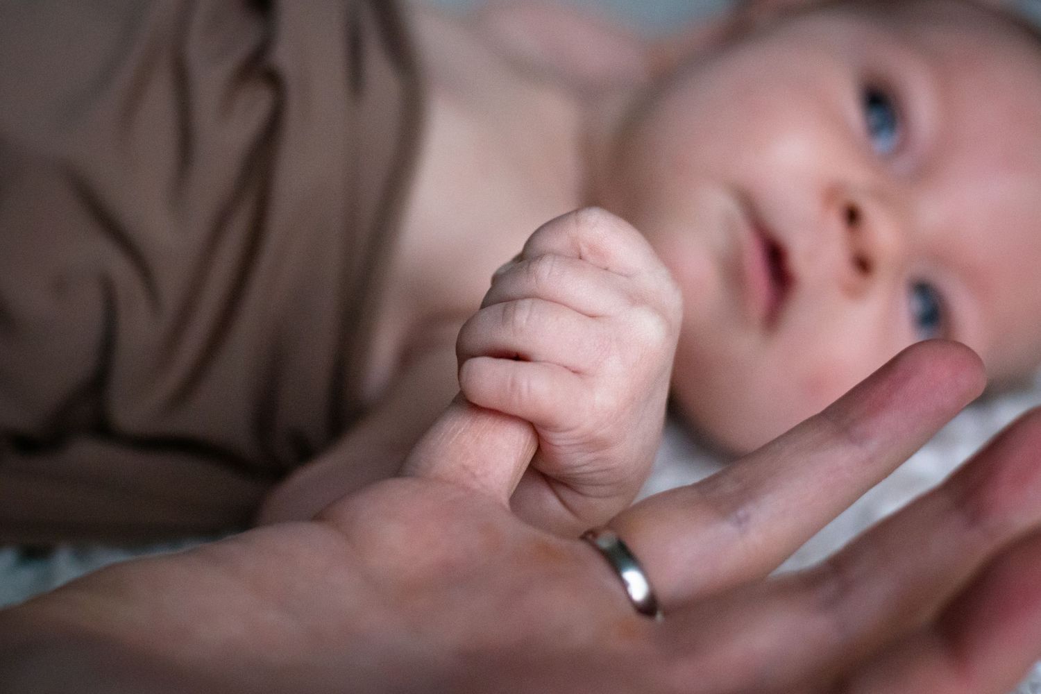 baby squeezing daddy's finger