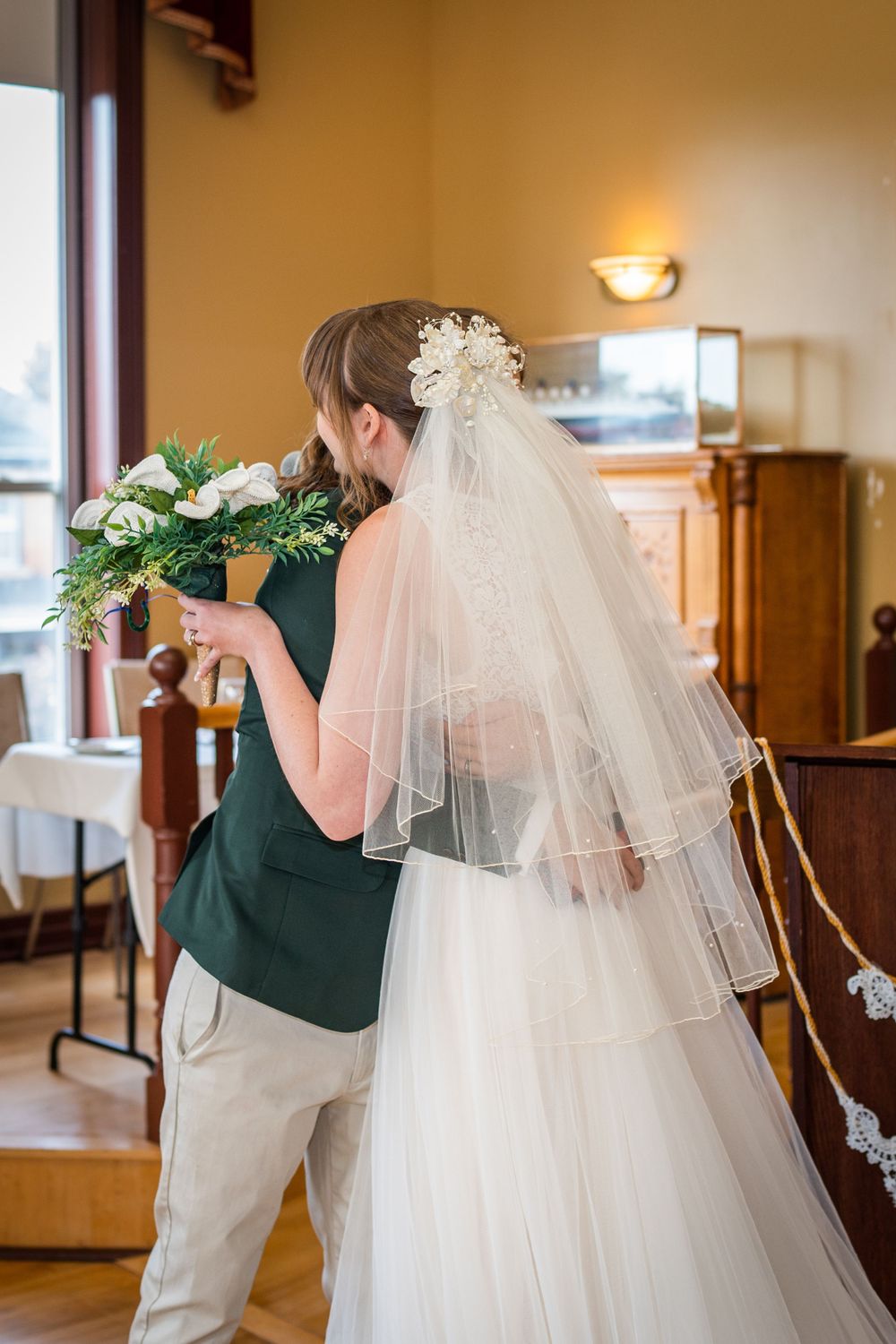wedding ceremony bride and groom hug acton town hall interior