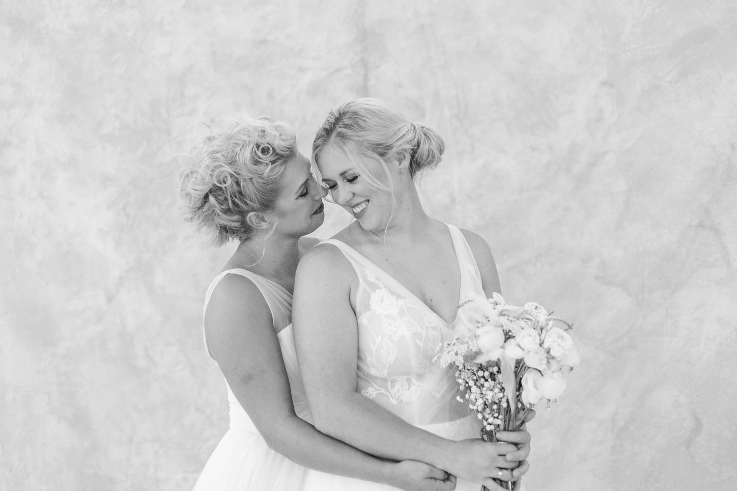 Romantic couple embraces in soft black and white portrait series showing tender moments and expressions.
