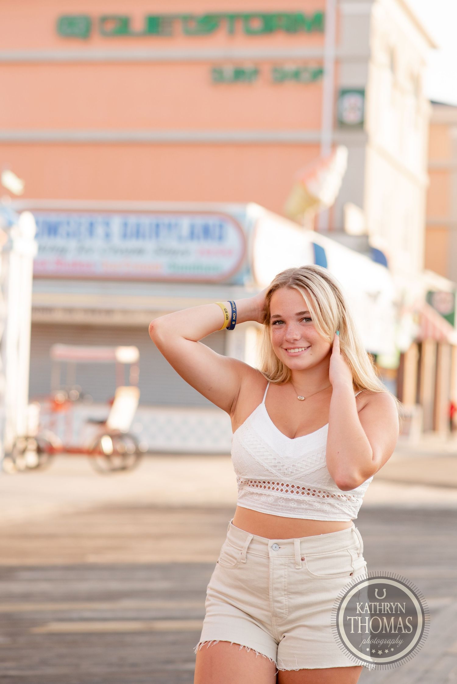A summery beach boardwalk scene with surf shop signage and casual coastal fashion.