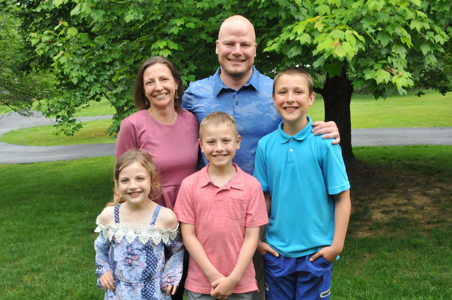 Family photo outside with three children