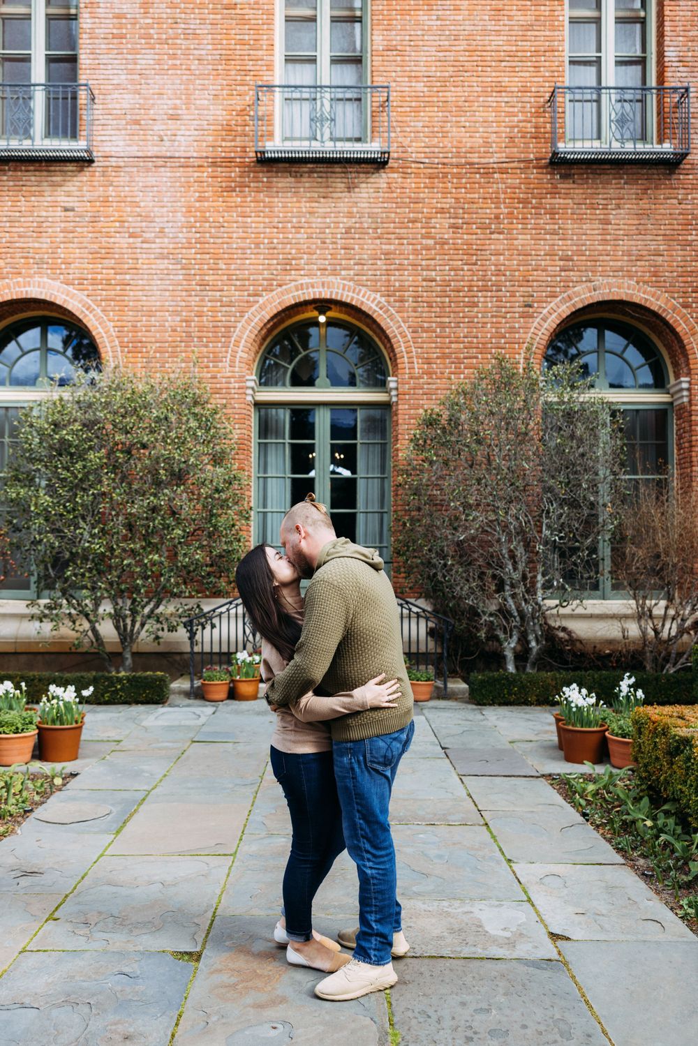 Couple kisses in front of historic house at Filoli.