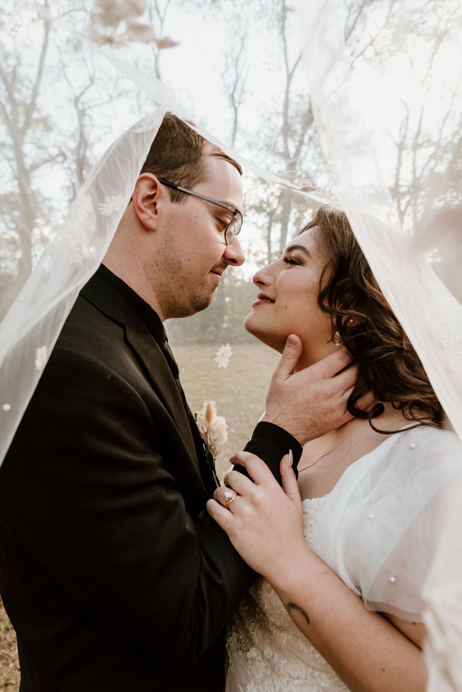 Intimate winter wedding portrait with romantic soft lighting and delicate veil.