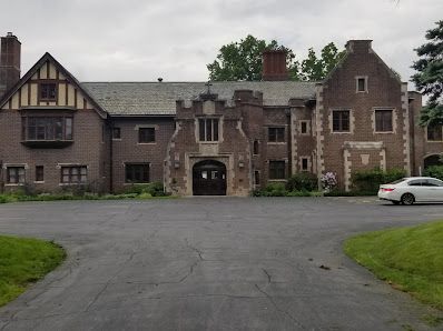 Tudor-style stone mansion with brick facade and Gothic architectural details.