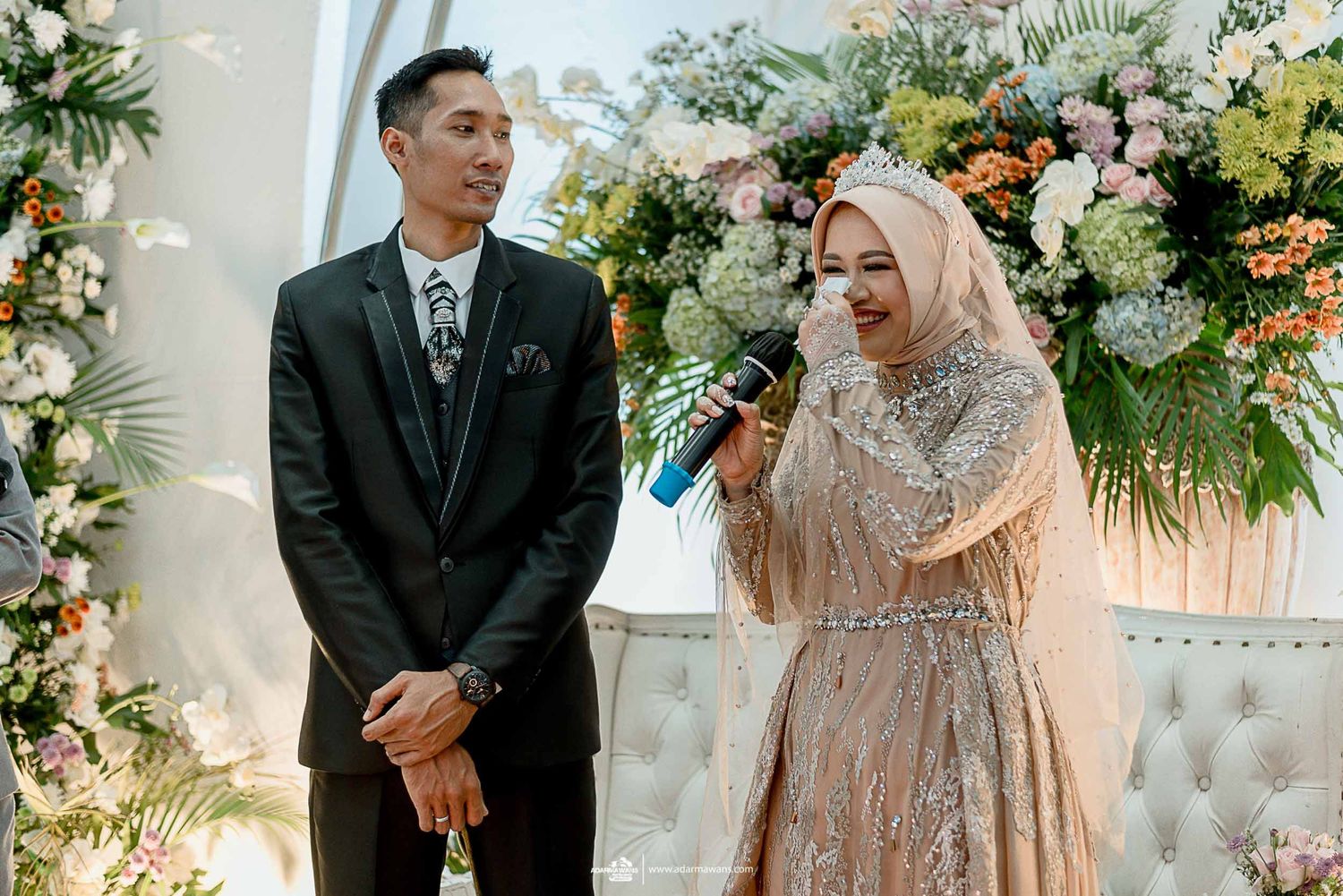 Candid moment of newlyweds sharing laughter during their wedding ceremony.