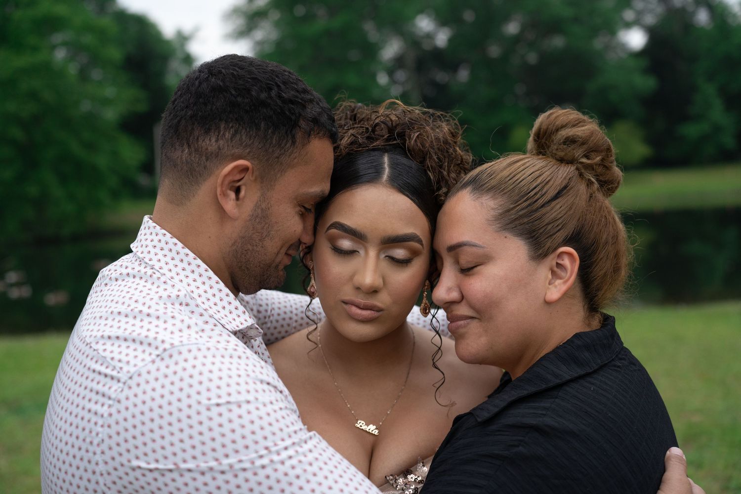A touching moment captured between daughter, mom and dad in an outdoor setting