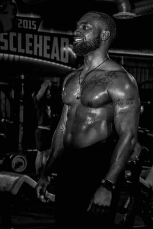 Black and white photo of muscular physique during intense gym workout session.