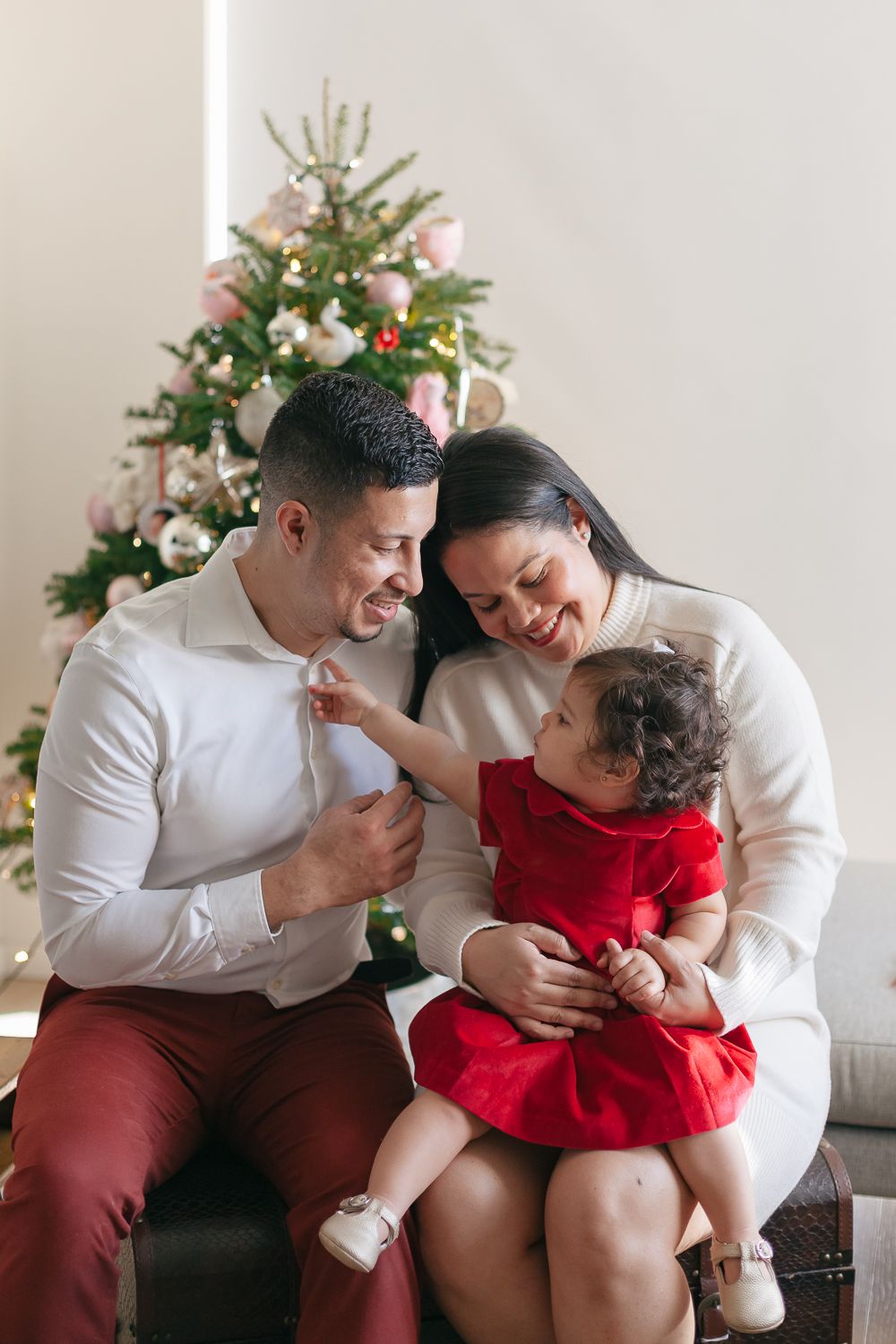 Cherished Family Time: Mom, Dad, and Daughter by the Christmas Tree - Paula Ortiz Photography NYC Holiday card photos