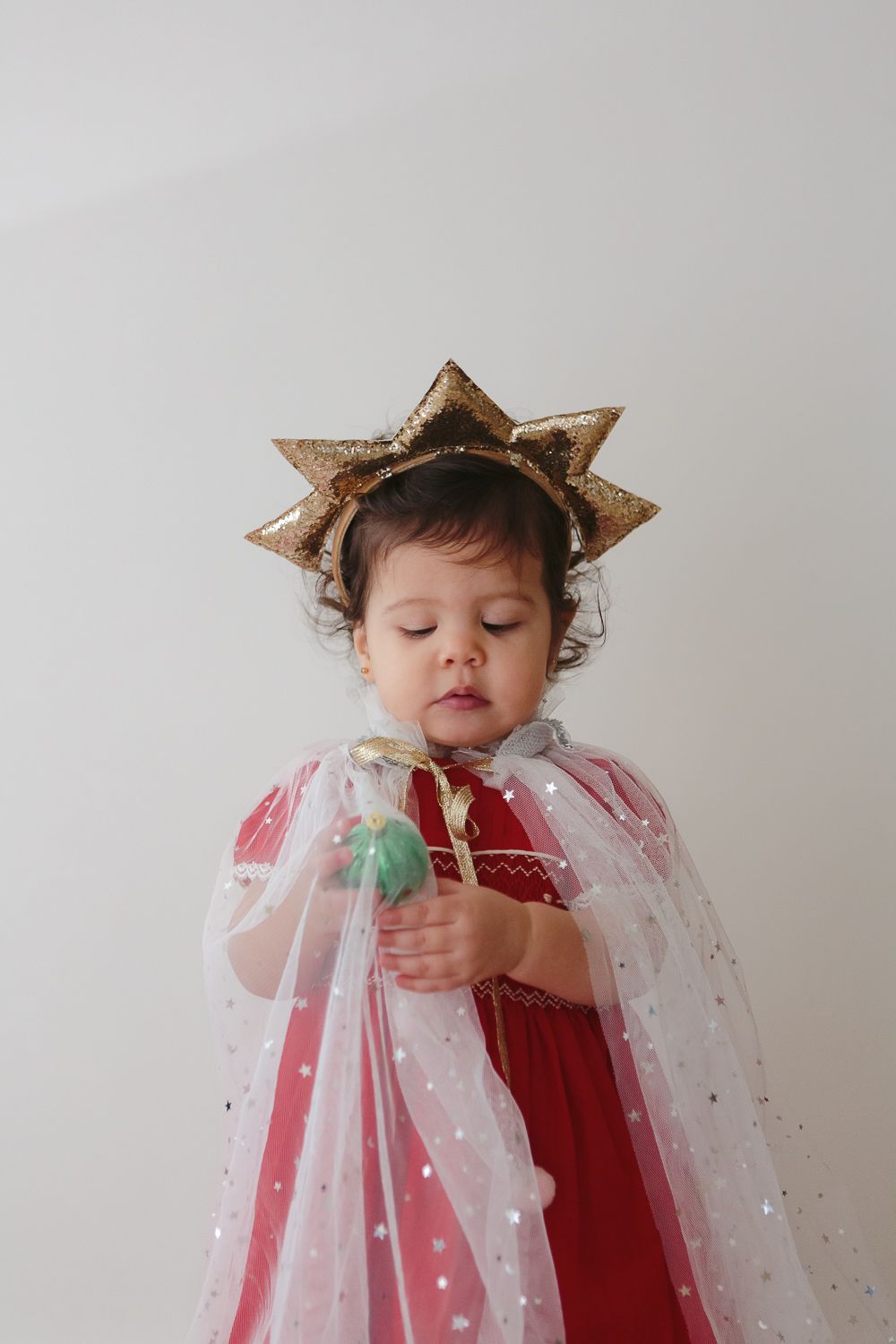 Festive Playtime: Girl in Cape and Star Band with Holiday Ornament - Paula Ortiz NYC Holiday Session
