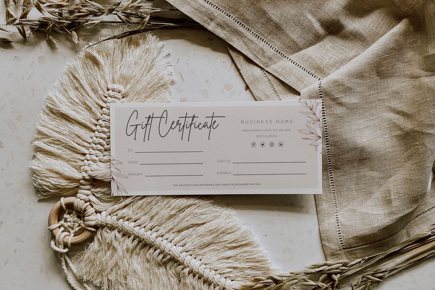 A blank gift certificate displayed on a beige textured fabric with fringe details.