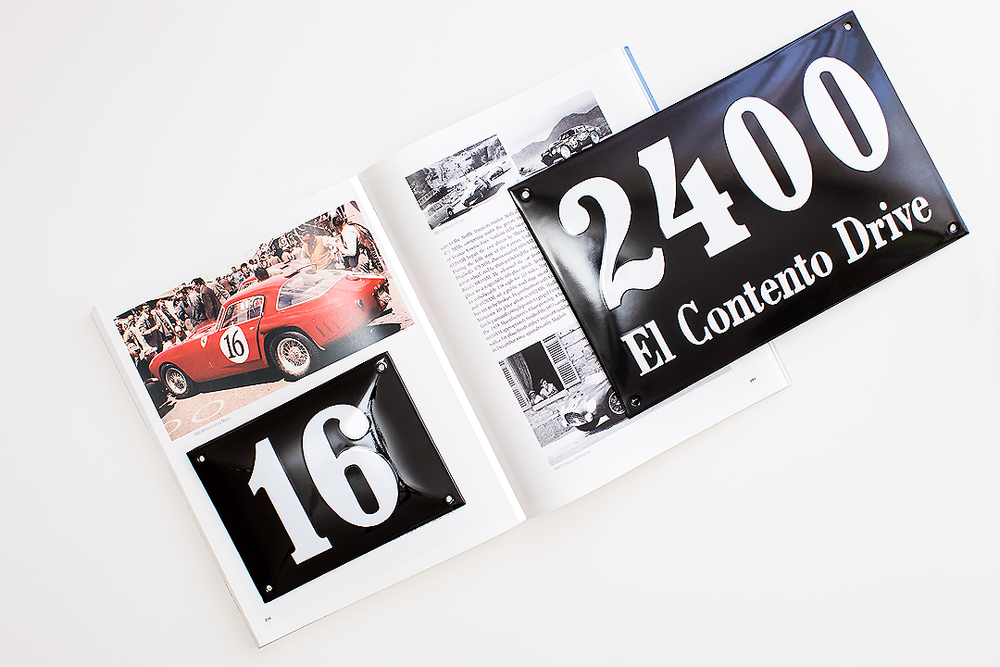 Open book or magazine spread showing vintage car photo and street number signage.