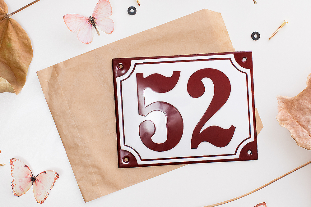 Vintage-style red house number 52 with decorative butterflies on kraft paper background.