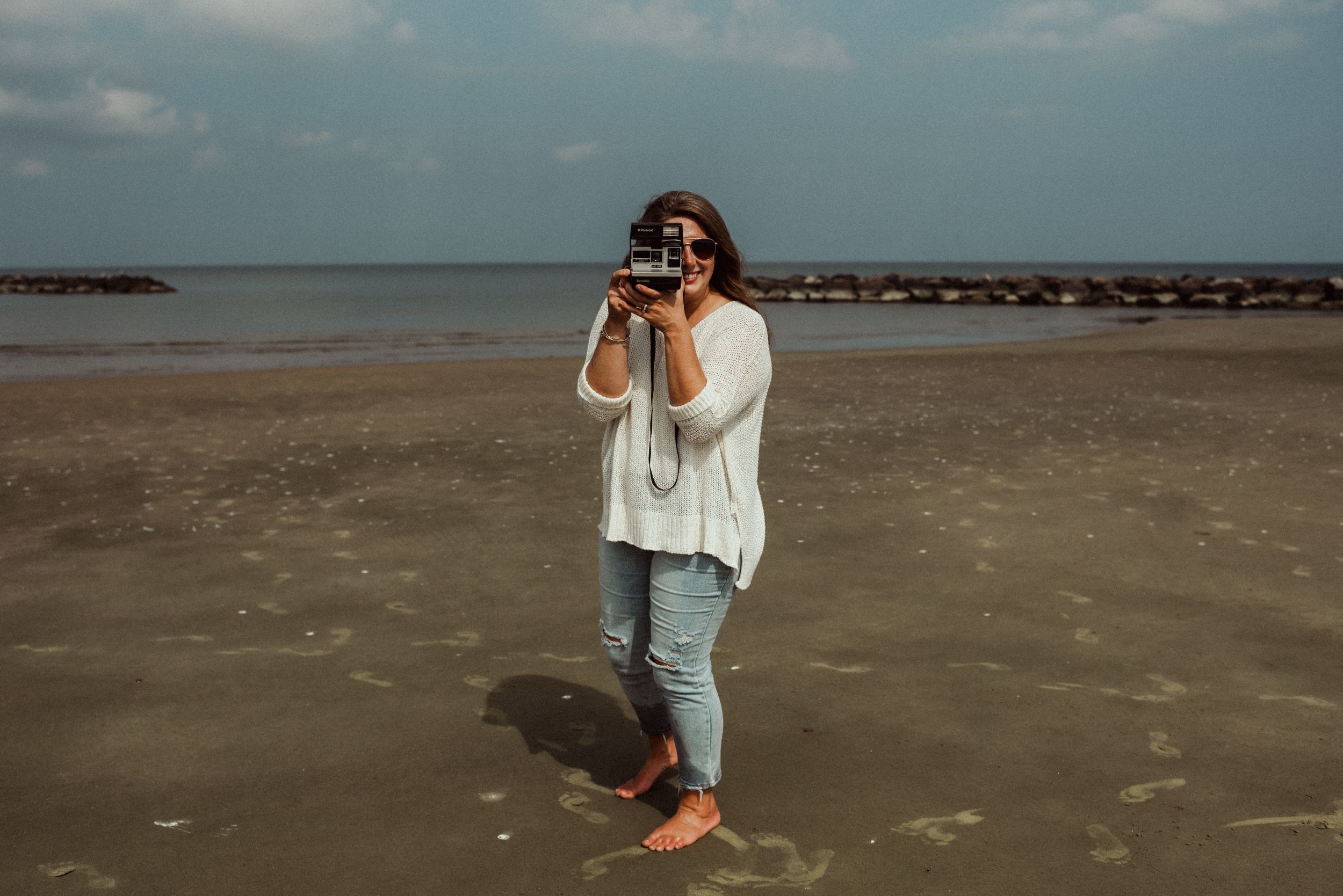 jessica hubbard on the beach in norfolk, virginia with a vintage polaroid instant camera