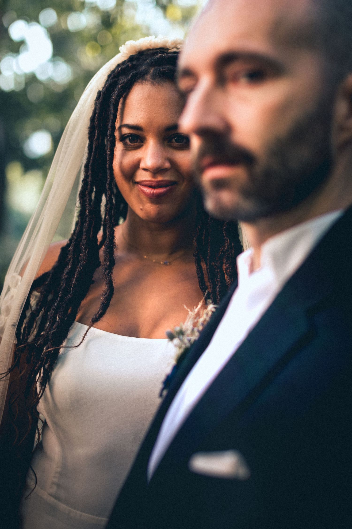 Closeup portrait of bride and groom standing together during outdoor wedding celebration.