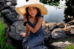 Artistic portraits featuring a vintage sun hat and blue dress against rocky backdrop.