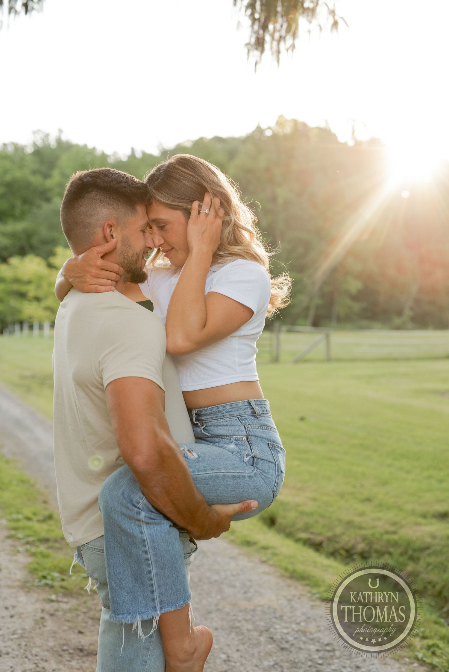 Intimate sunset moment between couple on rural pathway with golden light.