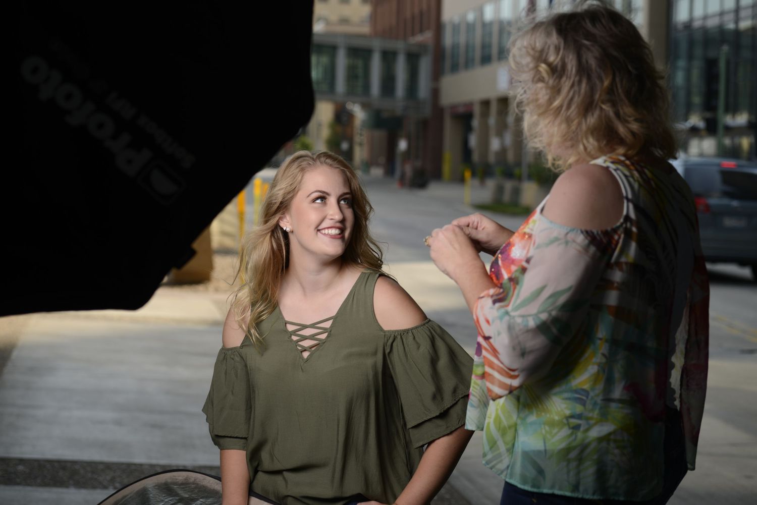 Two people chatting and laughing during an outdoor photo session.