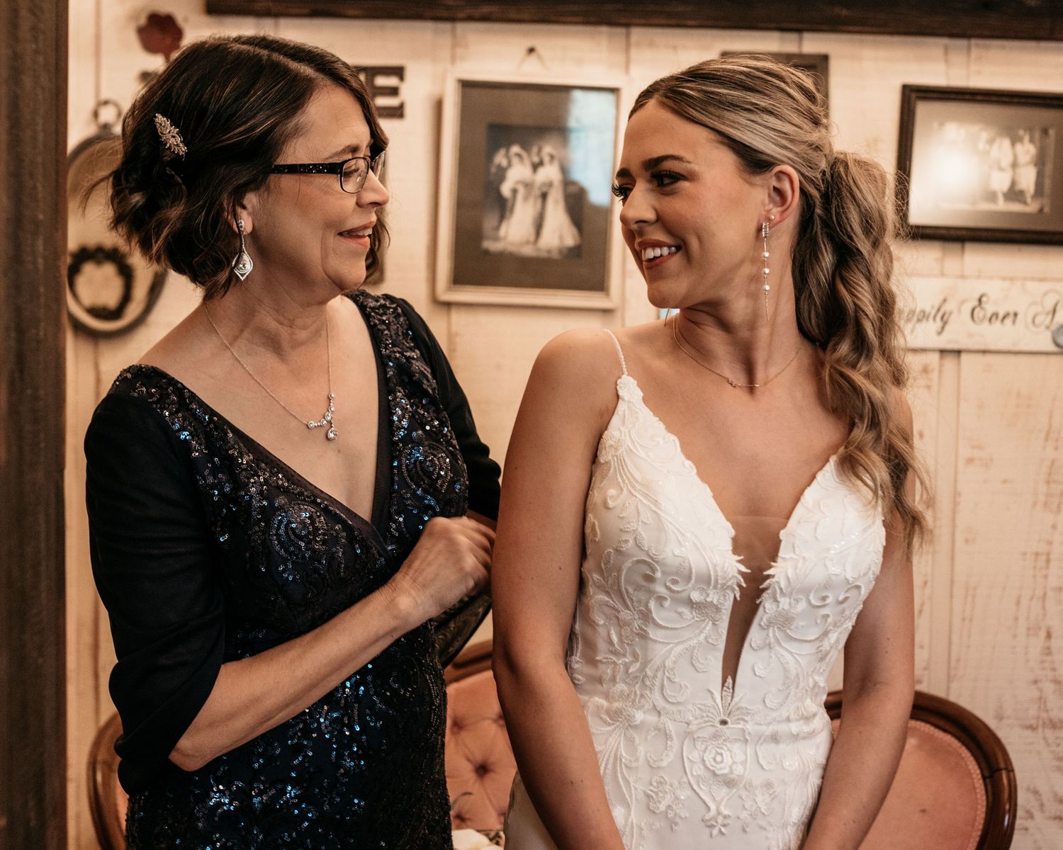 Two people share an emotional moment in formal attire against a rustic background.
