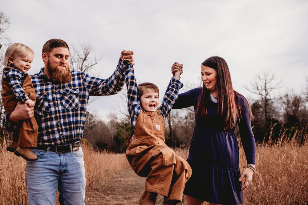 mom and dad swinging young son in fall photo