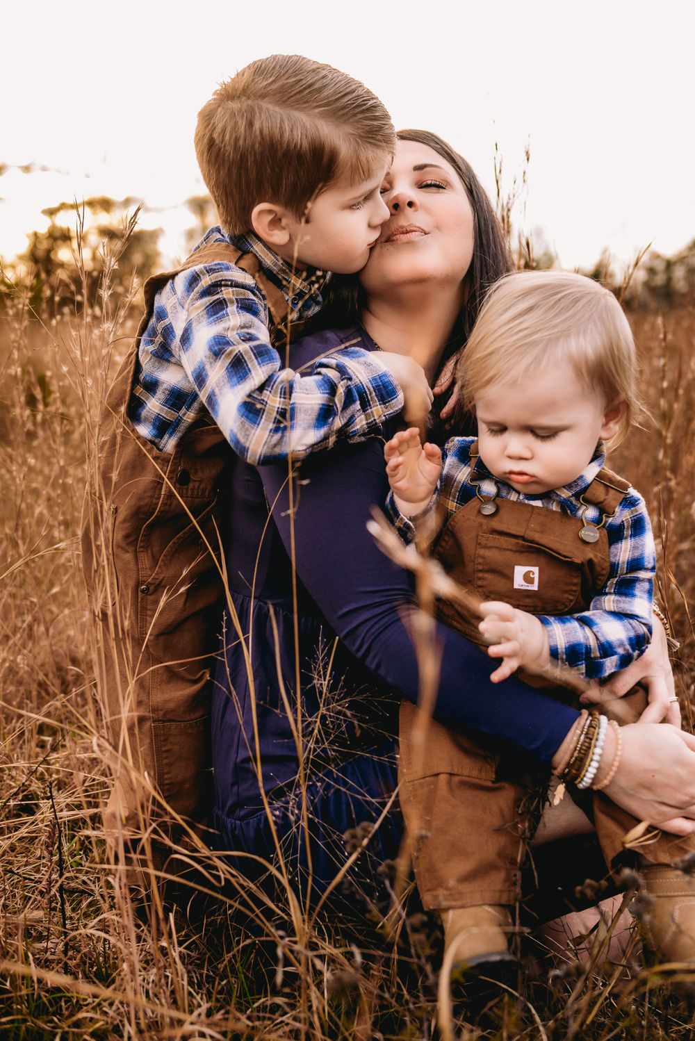 mother and two young sons in loving embrace