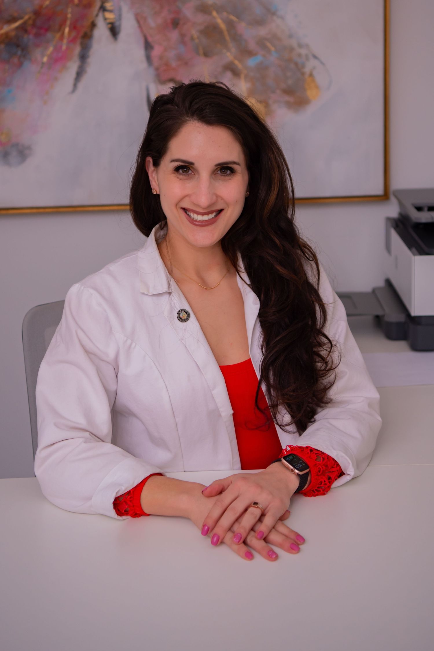 woman physician in white coat sitting at desk natalie gentile