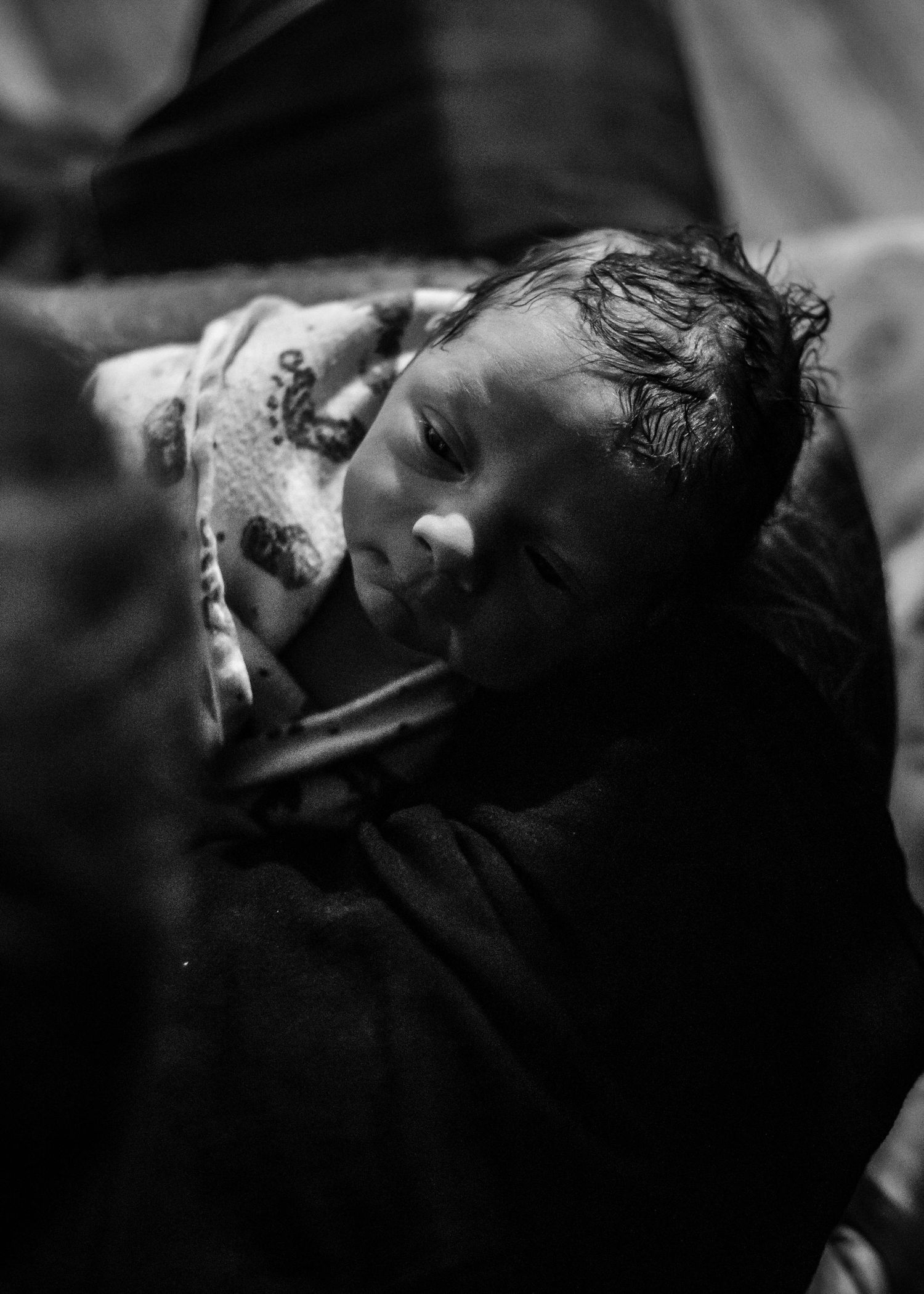 Newborn baby boy being held by his dad for the first time just after birth in Sioux City, IA.