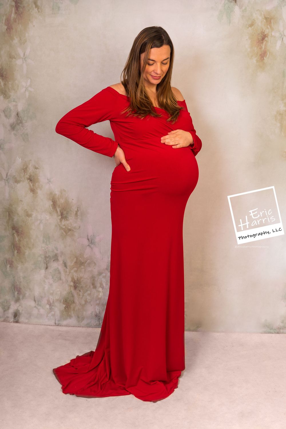 39 weeks pregnant admiring baby bump in red dress, Glenside PA, studio maternity shoot