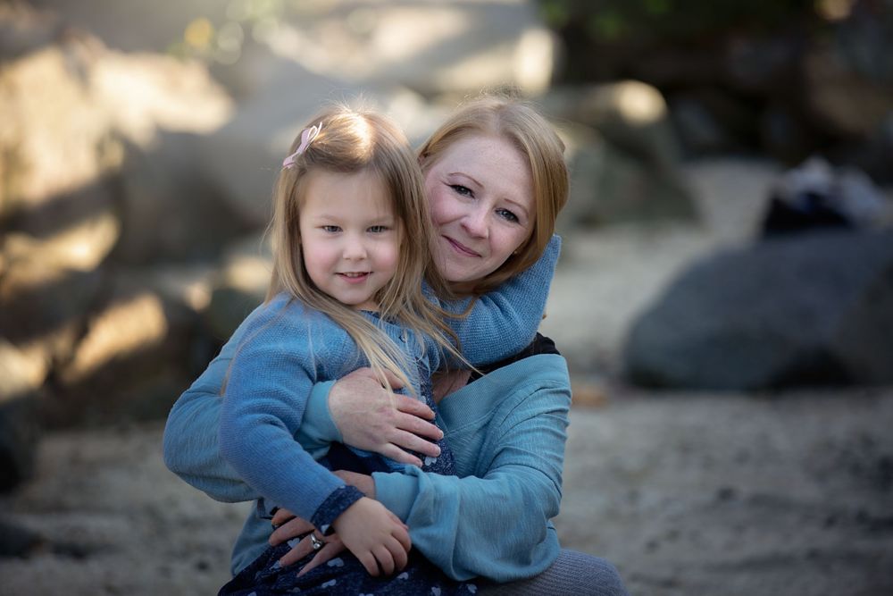 Mom and daughter having a big hug on the beach.