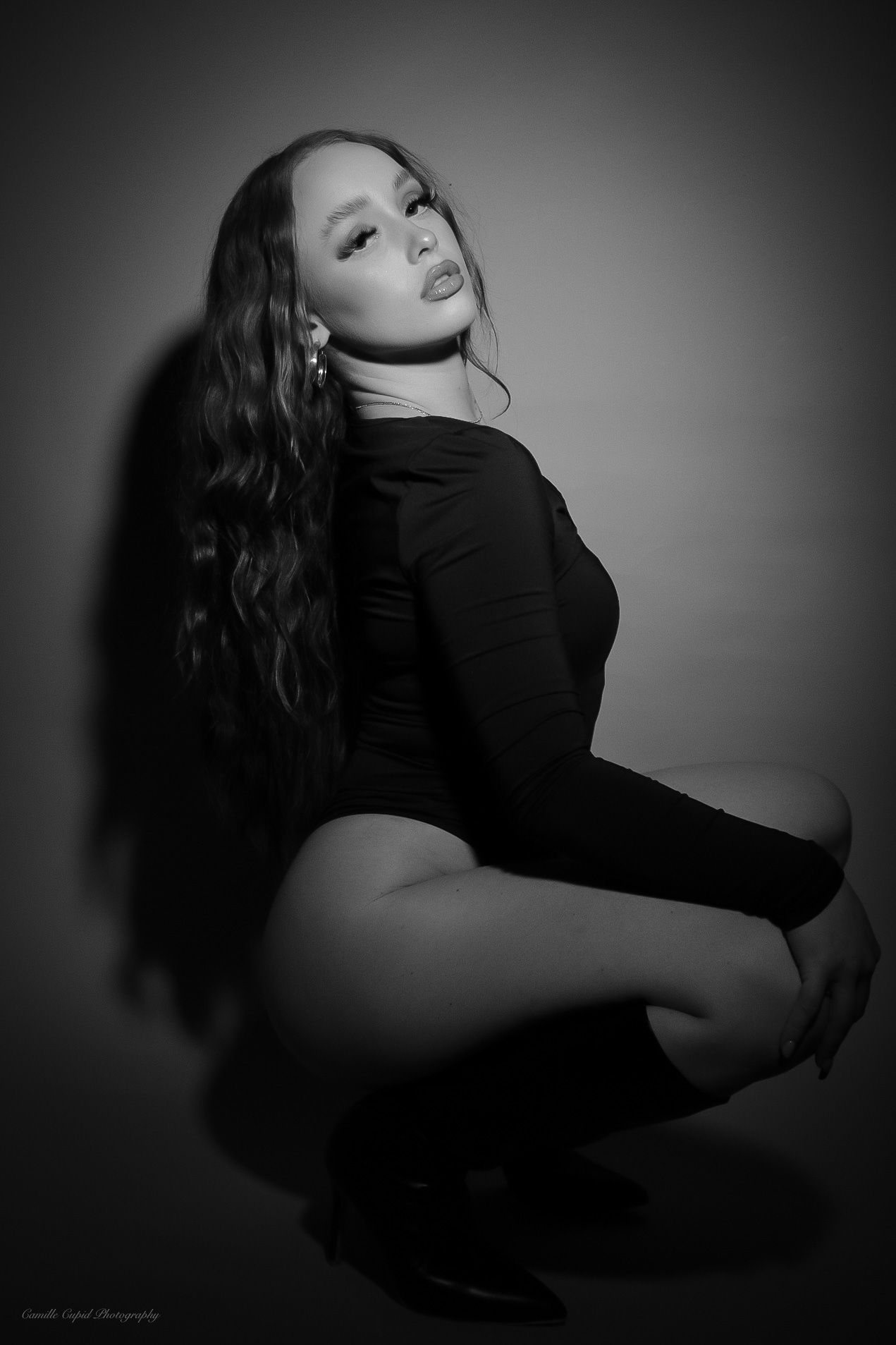 Black and white fashion photography featuring a feminine model wearing a Fashion Nova bodysuit