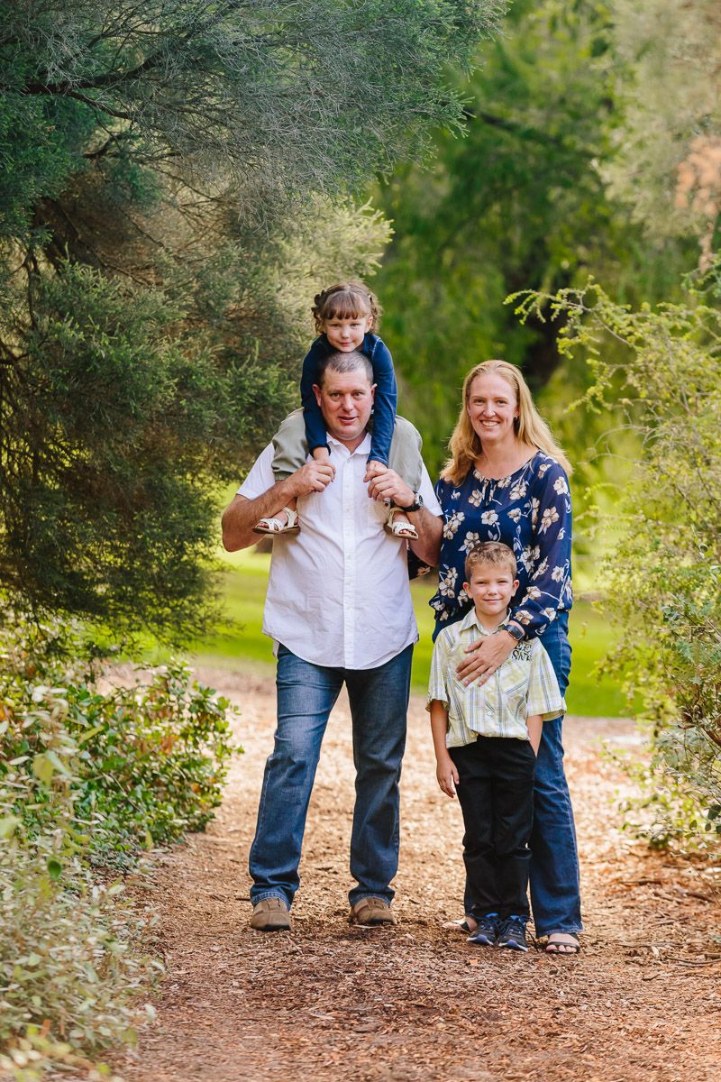 Family walking together on a forest trail during autumn.