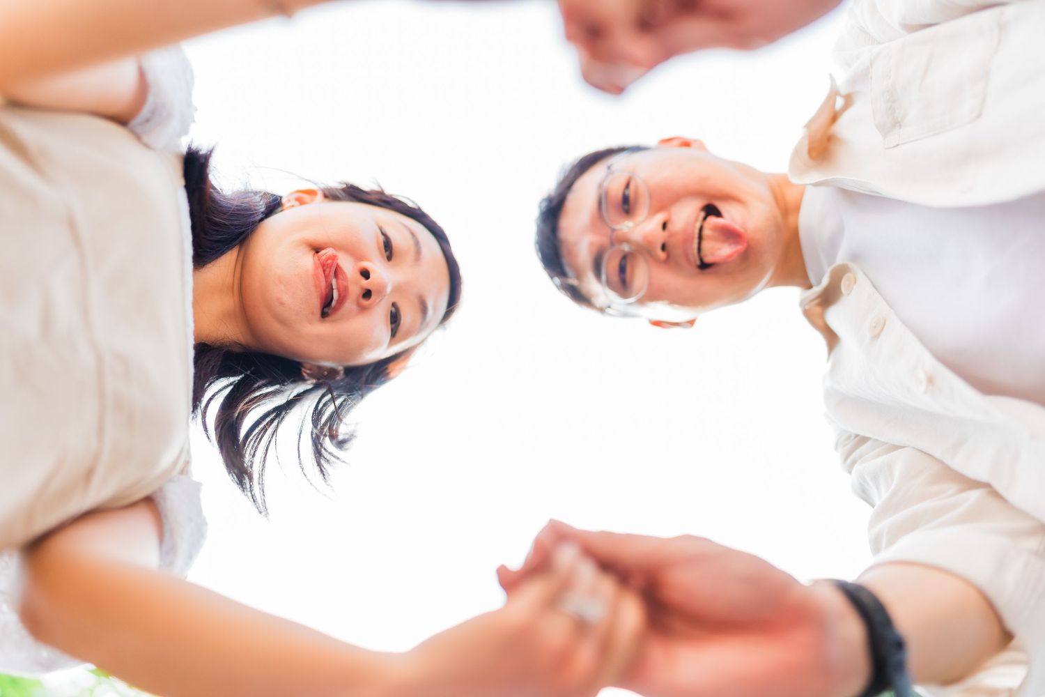 A joyful low-angle portrait shot against bright white background.