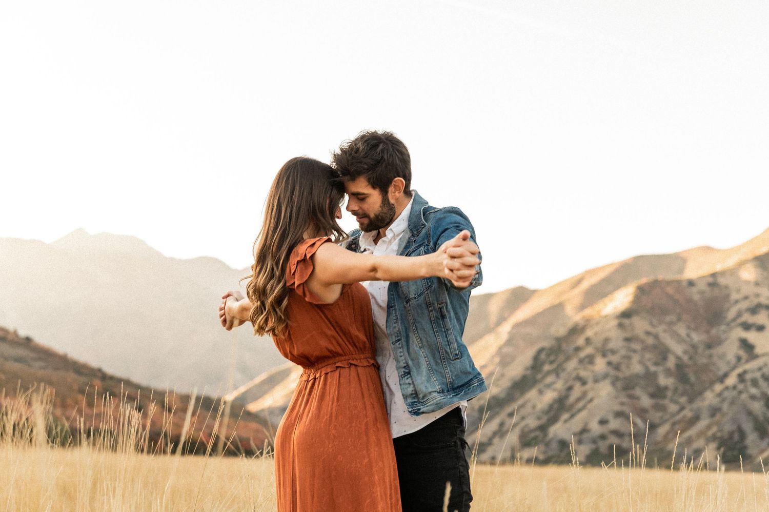 Romantic couple photos in casual wear against an autumn mountain landscape.