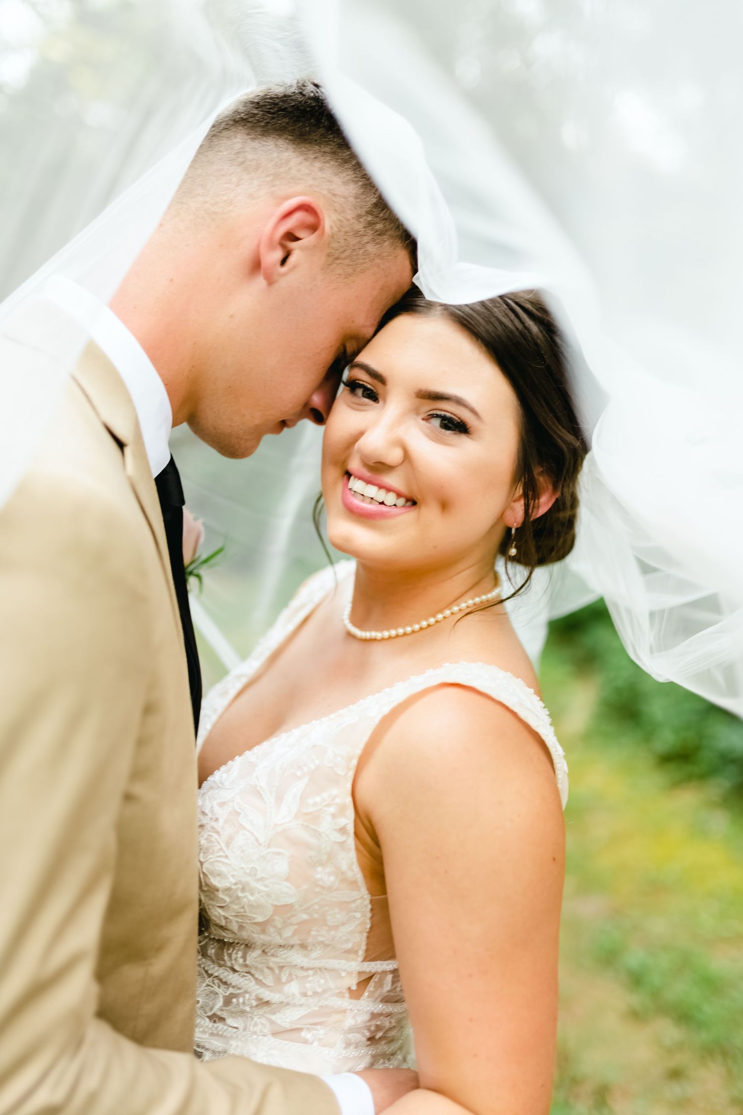 Wedding couple shares intimate moments in outdoor setting with soft natural lighting.