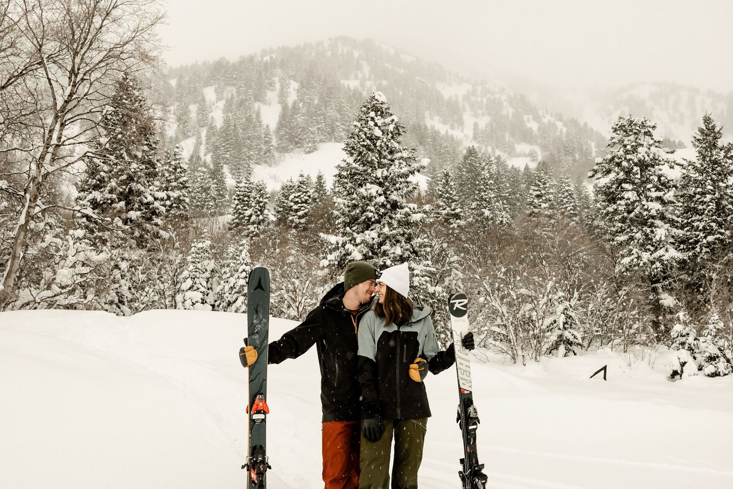 A romantic winter engagement photoshoot in a snowy forest landscape.