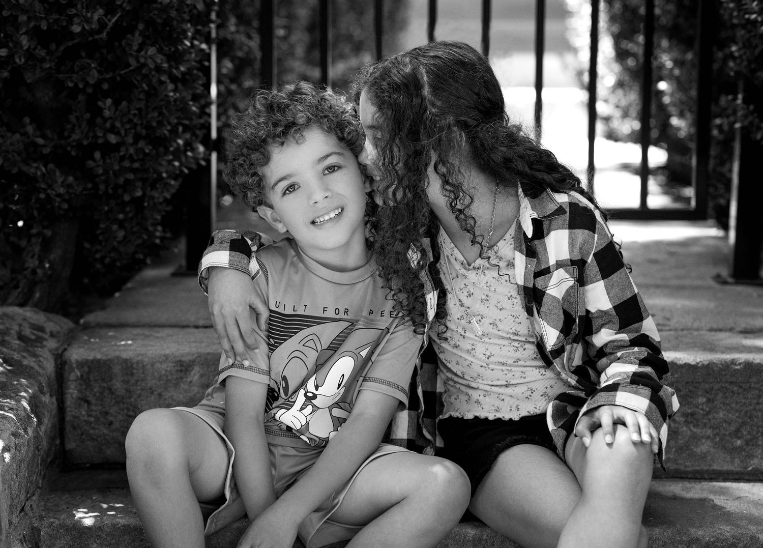 Two children sharing a playful moment on stone steps.