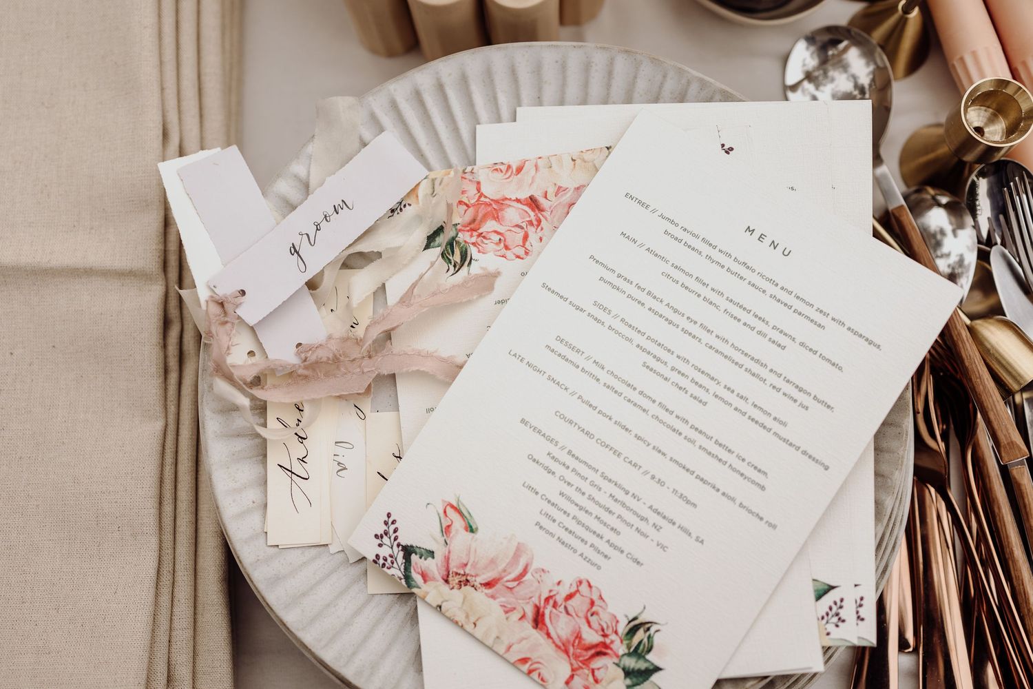 Outdoor table setting with white chairs and floral centerpiece.