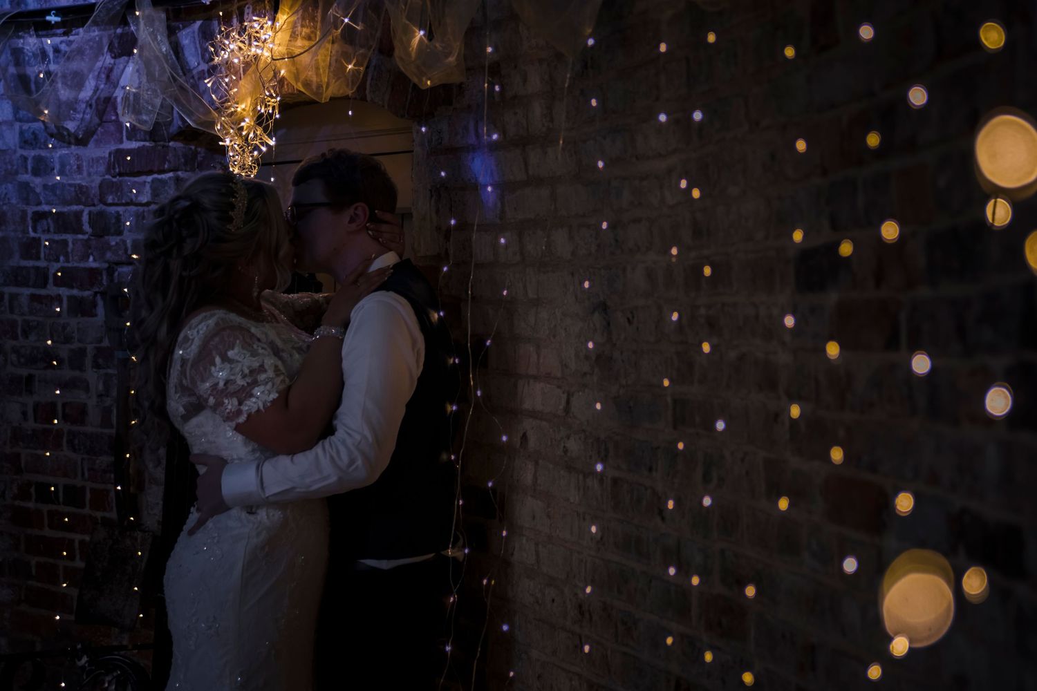 Bride and groom kiss against a wall, derbyshire wedding