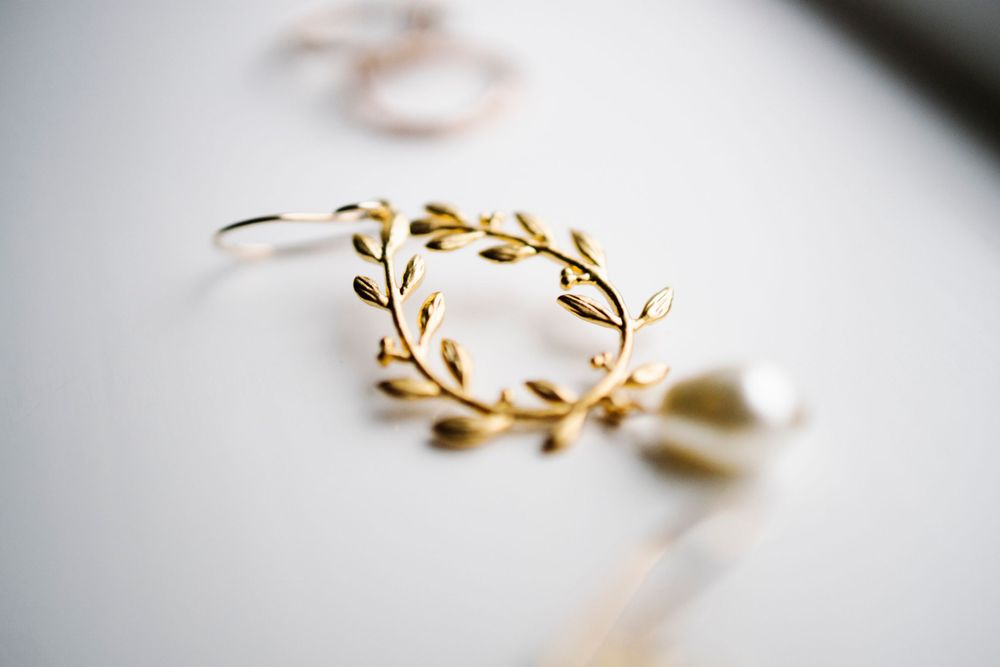 Gold leaf-design wedding hair accessory photographed with shallow depth of field.