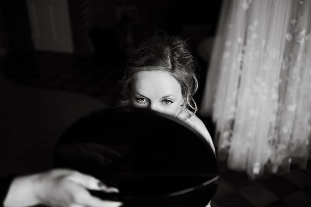 A creative portrait in black and white showing a reflection in a round mirror.