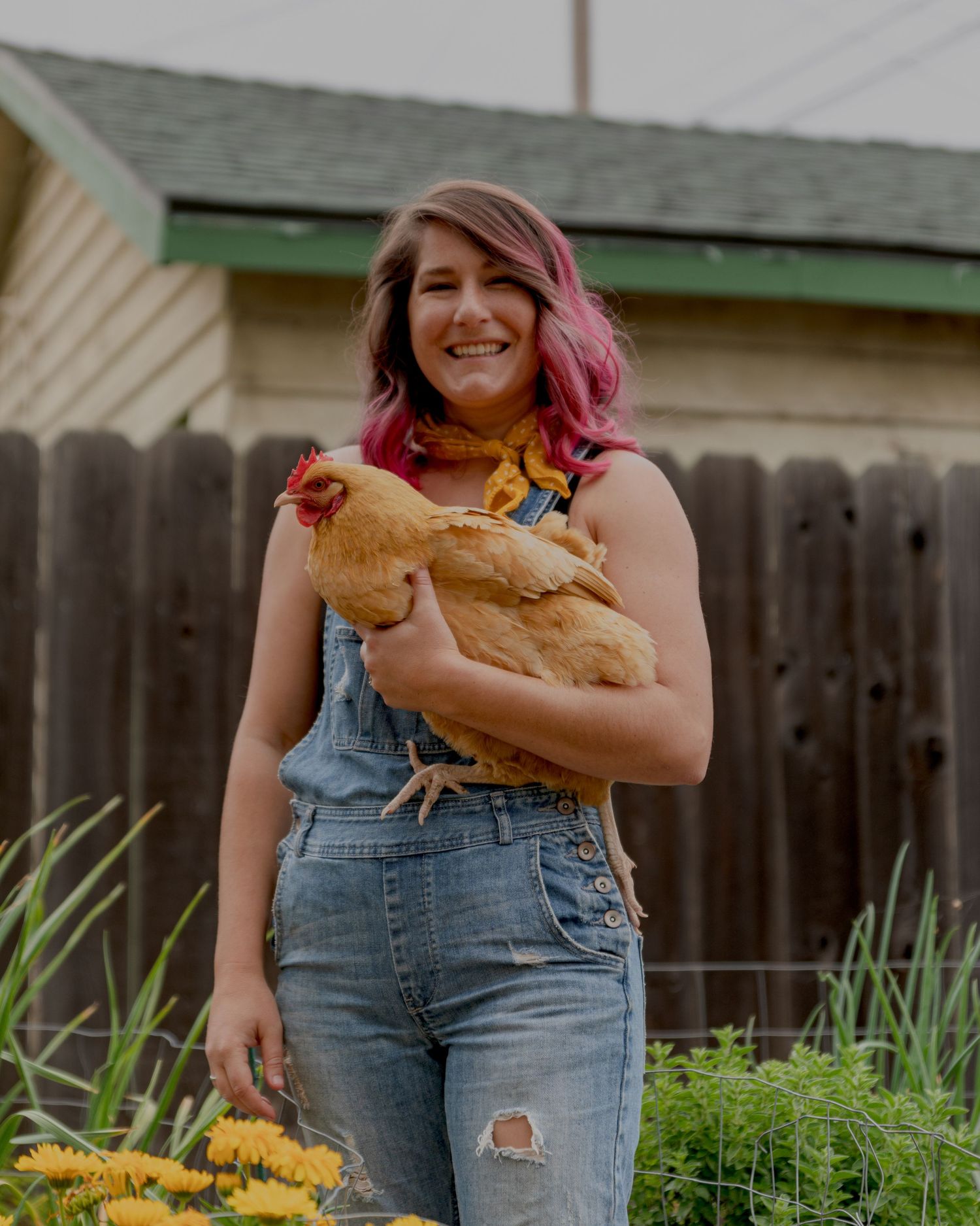 Woman with pink hair holding a yellow chicken