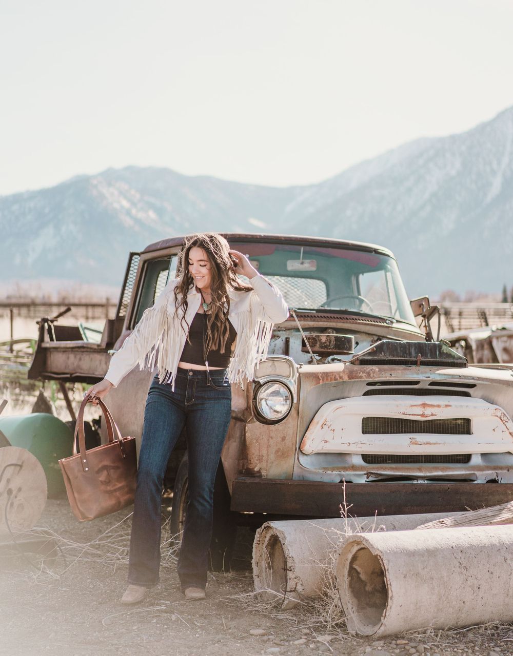 Vintage trucks and western styling against mountain backdrop in desert setting.