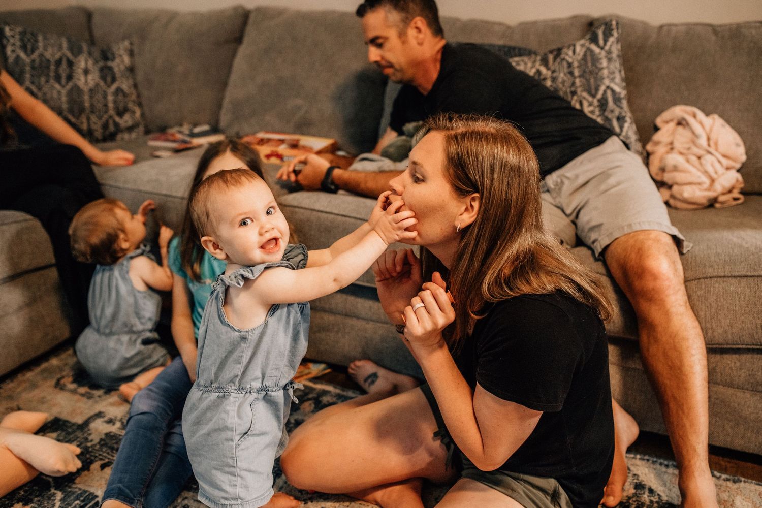 toddler grabbing mom's face during family game night at their home
