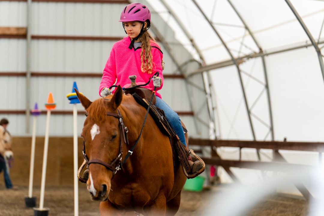 girl riding horse through the cones